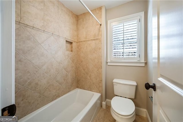 bathroom featuring tiled shower / bath combo and toilet