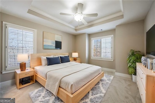 bedroom featuring light carpet, ornamental molding, a raised ceiling, and ceiling fan