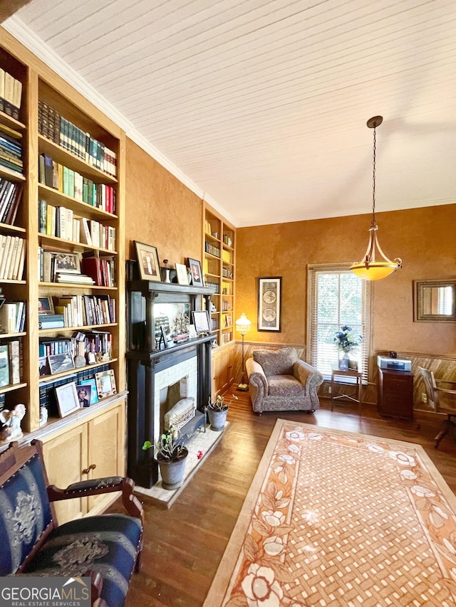 sitting room featuring crown molding, built in features, and hardwood / wood-style flooring