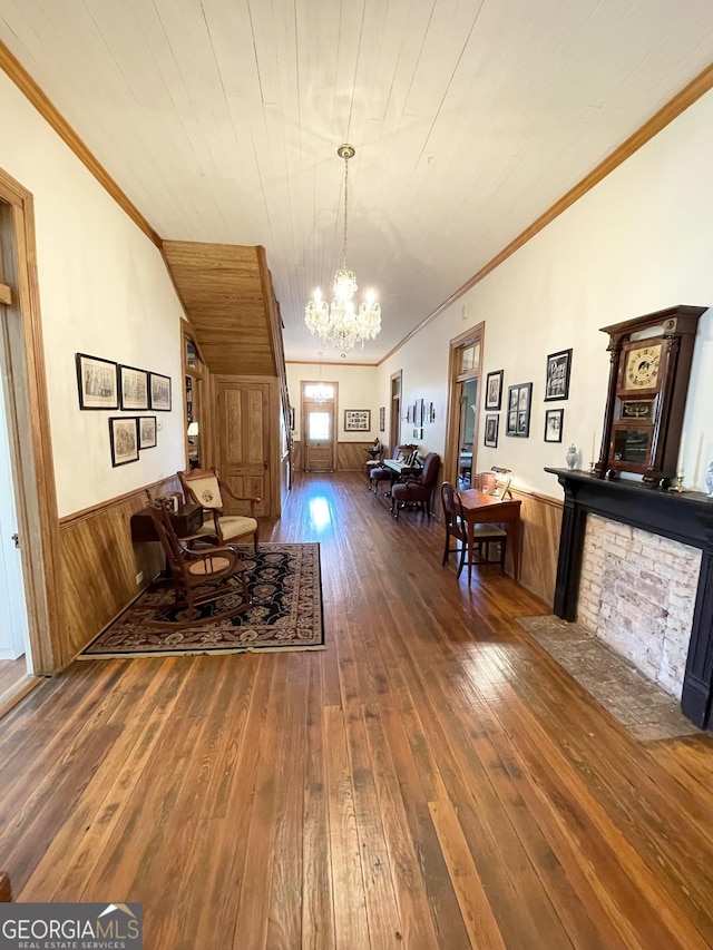 interior space featuring dark wood-type flooring, crown molding, and an inviting chandelier