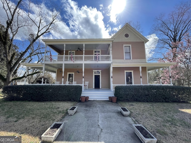 view of front of property featuring ceiling fan, a front lawn, and a porch