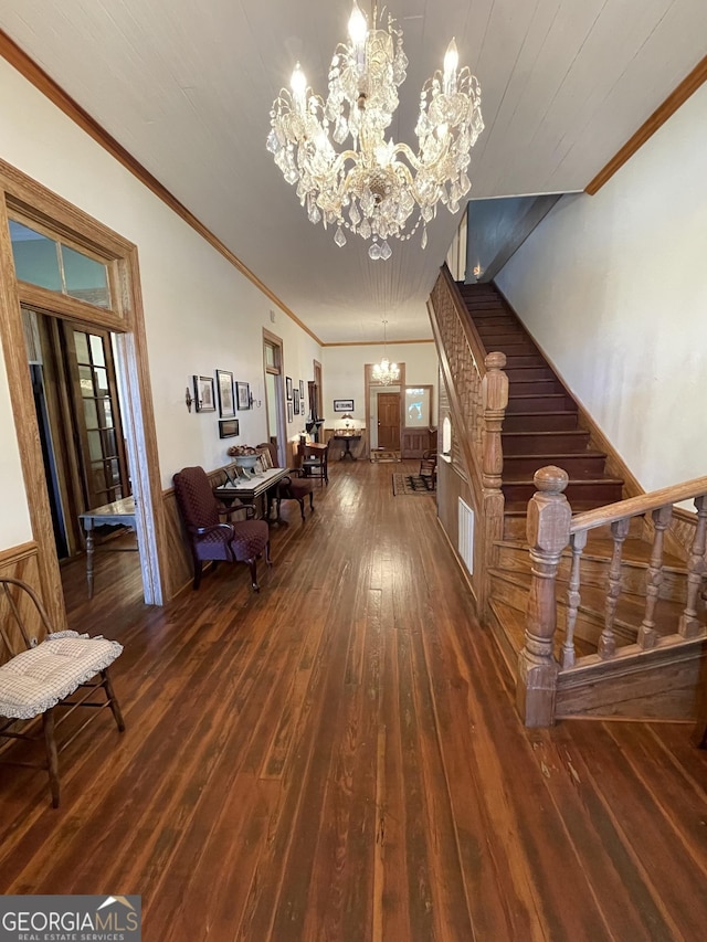 living room featuring dark hardwood / wood-style flooring, an inviting chandelier, and ornamental molding