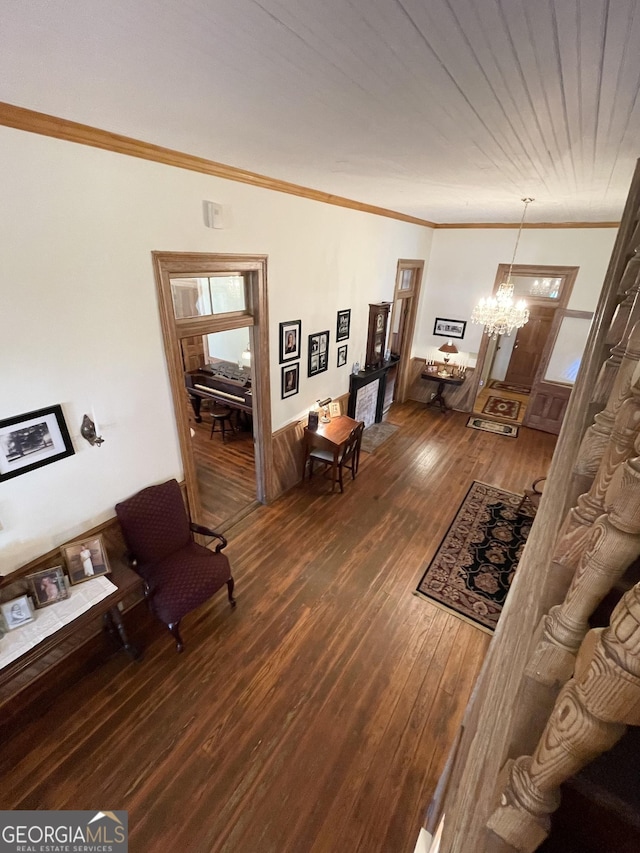 living room featuring dark hardwood / wood-style flooring, crown molding, and a notable chandelier