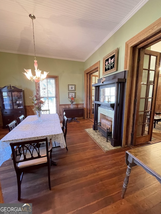 dining area with hardwood / wood-style floors, crown molding, and a chandelier