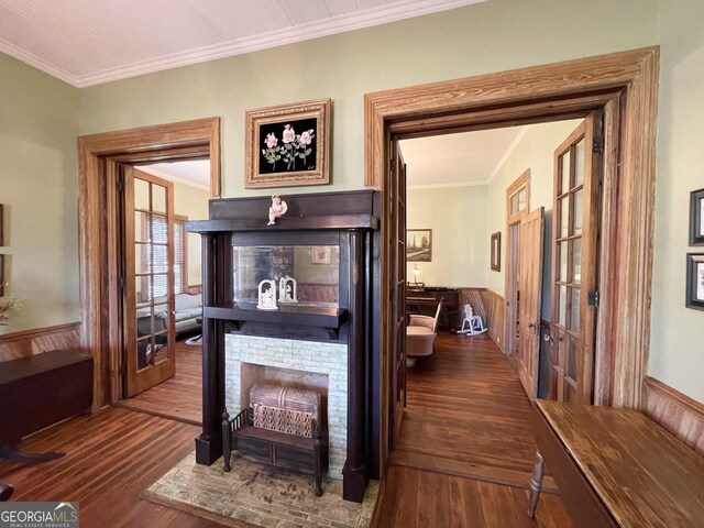 hall featuring wood walls, dark hardwood / wood-style floors, ornamental molding, and french doors