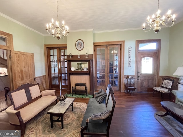 living room with french doors, dark hardwood / wood-style flooring, ornamental molding, and a notable chandelier