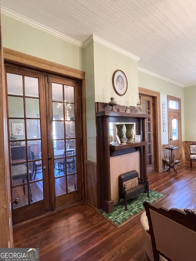 interior space with wood-type flooring, ornamental molding, french doors, and wooden walls