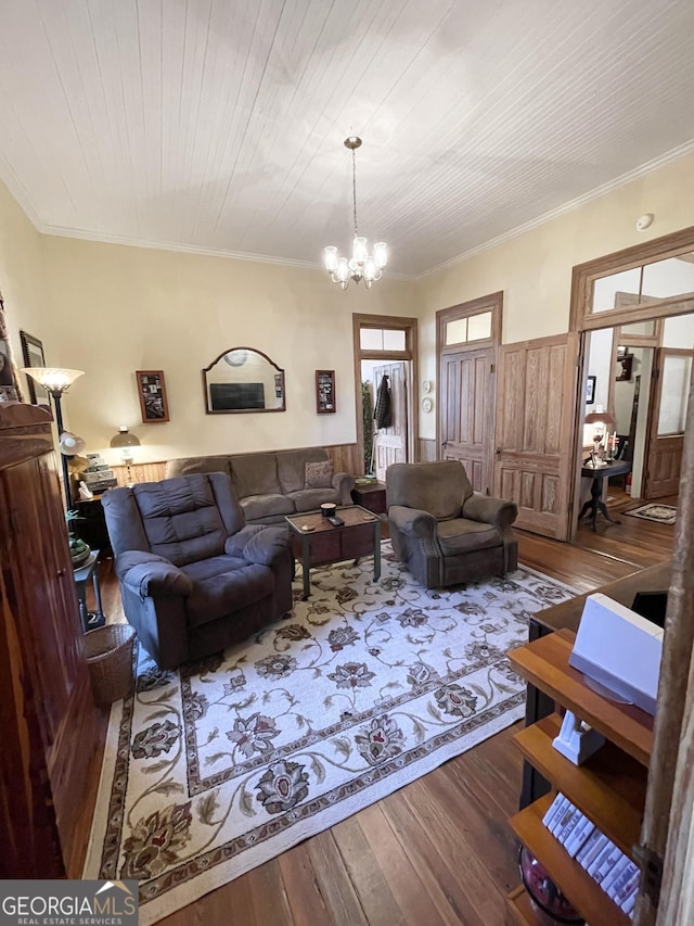 living room featuring wood-type flooring, wood ceiling, a chandelier, and ornamental molding