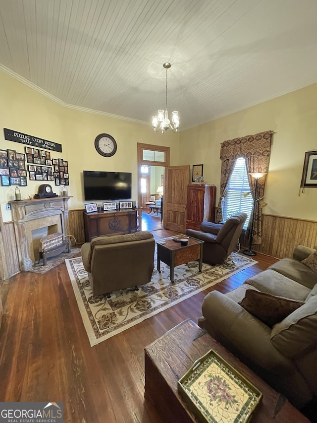 living room featuring hardwood / wood-style flooring, crown molding, and an inviting chandelier