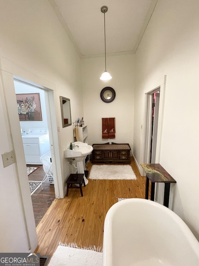 interior space with separate washer and dryer, ornamental molding, and light hardwood / wood-style flooring