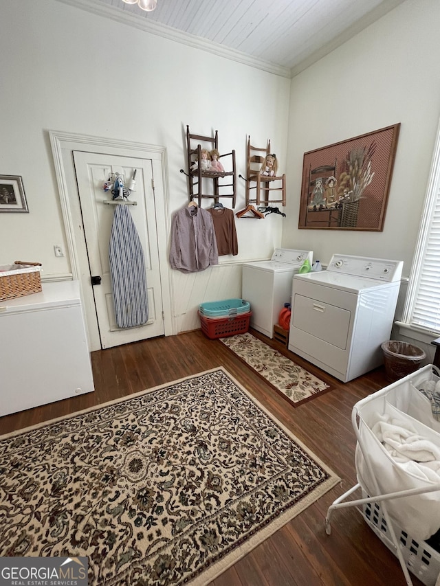 clothes washing area featuring washing machine and dryer, dark wood-type flooring, and ornamental molding