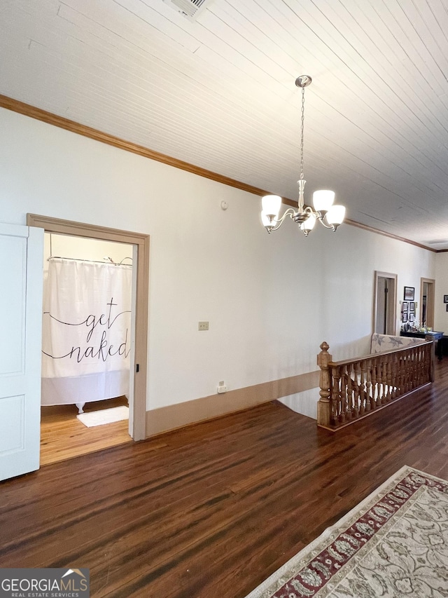 unfurnished room with a notable chandelier, crown molding, and hardwood / wood-style floors