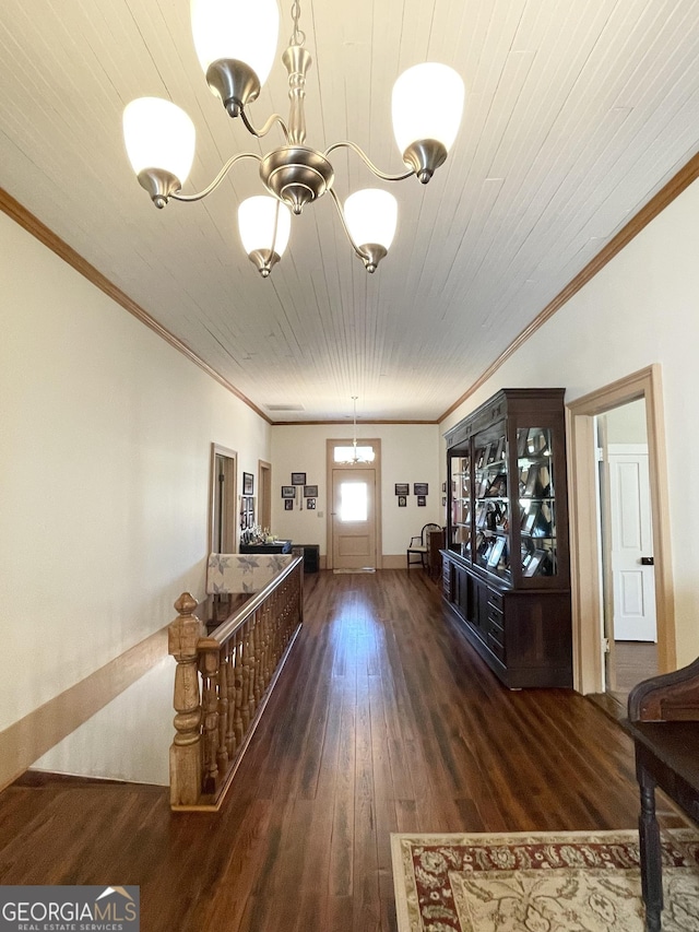 interior space with dark wood-type flooring, a chandelier, ornamental molding, and wood ceiling