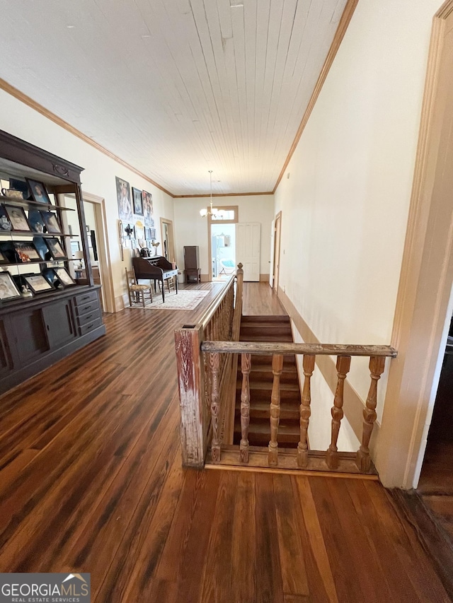 stairway featuring wooden ceiling, a chandelier, ornamental molding, and wood-type flooring