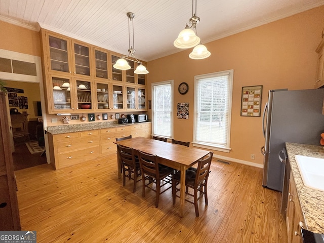 dining area with sink, light hardwood / wood-style flooring, and ornamental molding