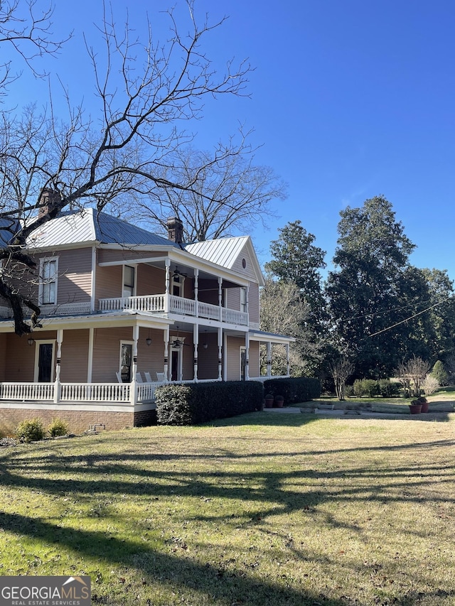 view of front of property featuring a front yard, a porch, and a balcony