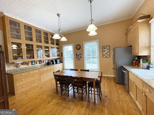 kitchen featuring light hardwood / wood-style floors, stainless steel dishwasher, sink, hanging light fixtures, and light stone counters