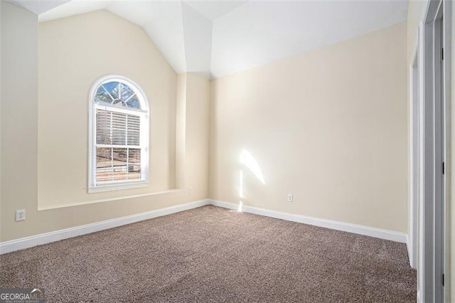 carpeted empty room featuring lofted ceiling