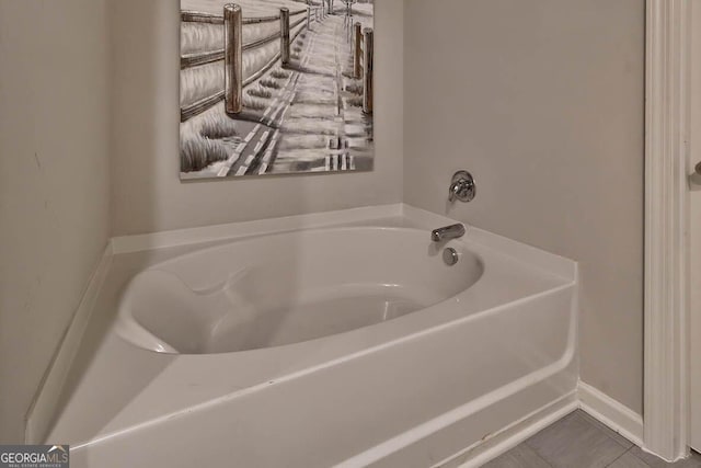 bathroom with a tub and tile patterned floors