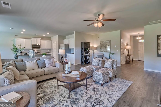 living room featuring ceiling fan and hardwood / wood-style flooring