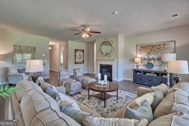 living room with ceiling fan and dark hardwood / wood-style flooring