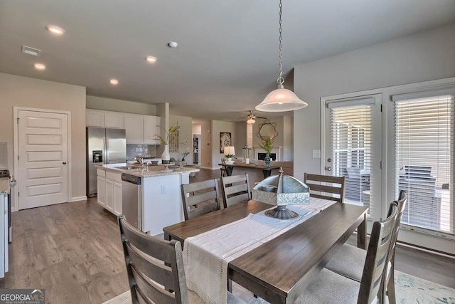 dining space with ceiling fan, sink, and light hardwood / wood-style floors