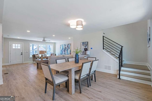 dining area with light wood-type flooring and ceiling fan