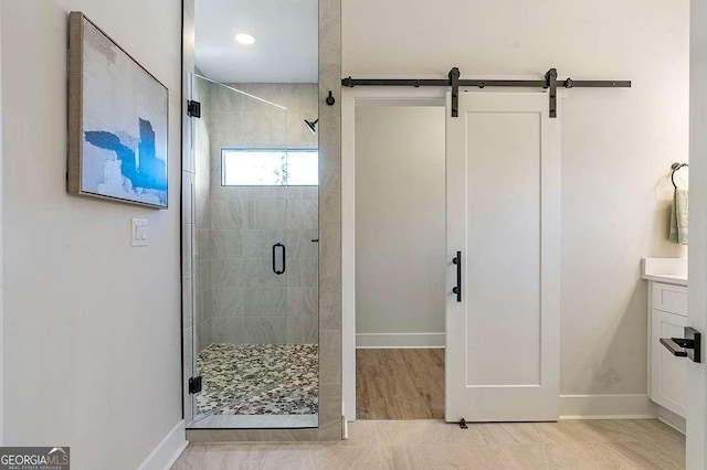 bathroom with a shower with shower door and vanity