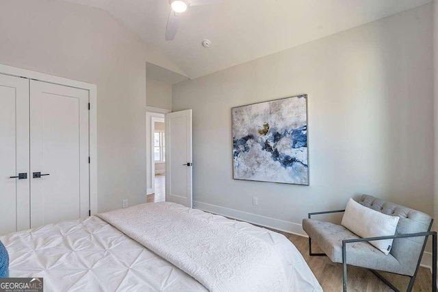 bedroom with ceiling fan, vaulted ceiling, and a closet