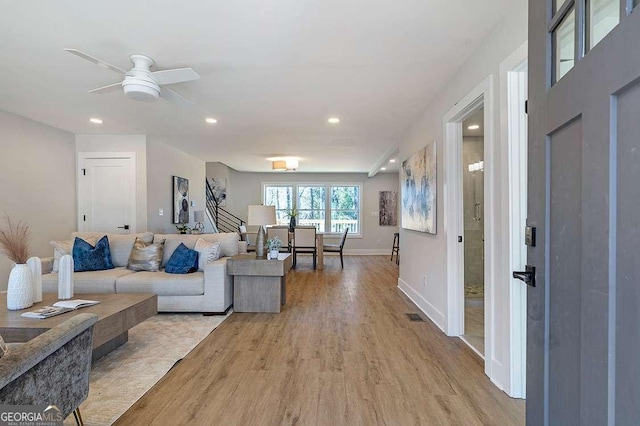 living room featuring ceiling fan and light wood-type flooring