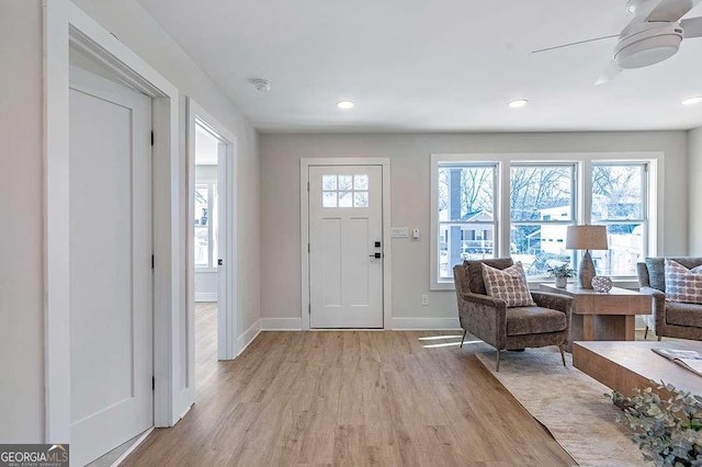 foyer with ceiling fan and light wood-type flooring