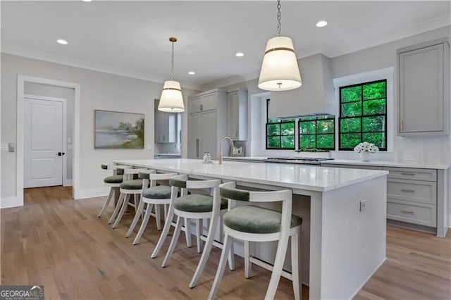 kitchen with a kitchen breakfast bar, gray cabinets, hanging light fixtures, and a large island