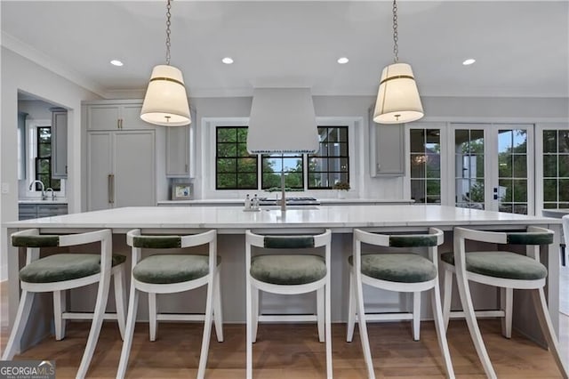 kitchen featuring decorative light fixtures, gray cabinets, and a breakfast bar area