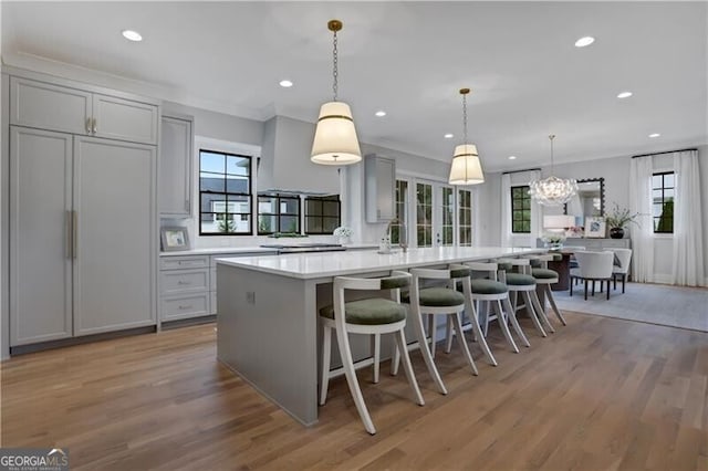 kitchen featuring ornamental molding, gray cabinetry, and hanging light fixtures