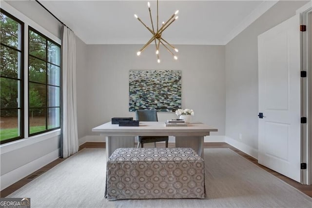 home office with wood-type flooring and a chandelier