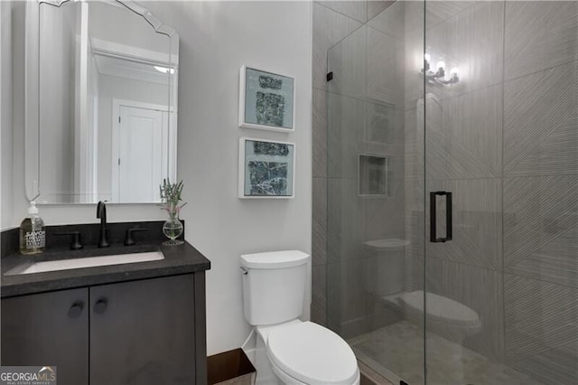 bathroom with toilet, a shower with door, and vanity