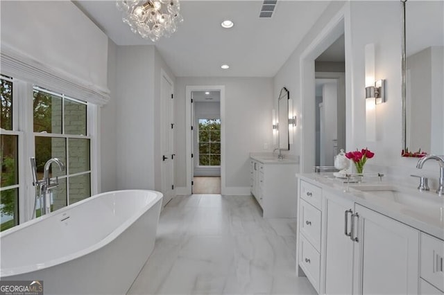 bathroom featuring a tub to relax in, vanity, and a notable chandelier