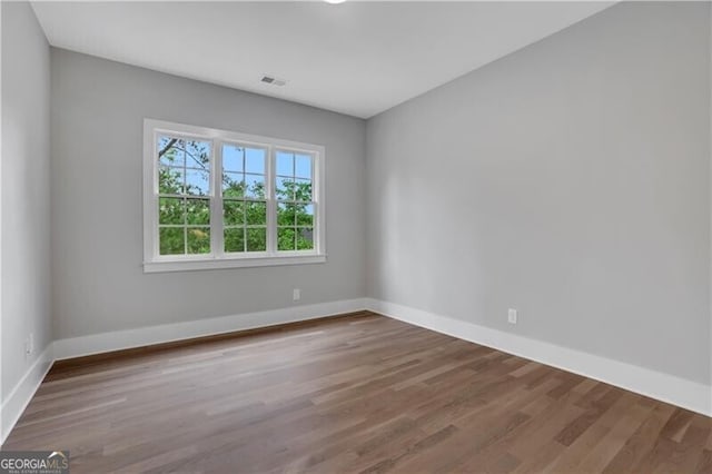 spare room featuring wood-type flooring