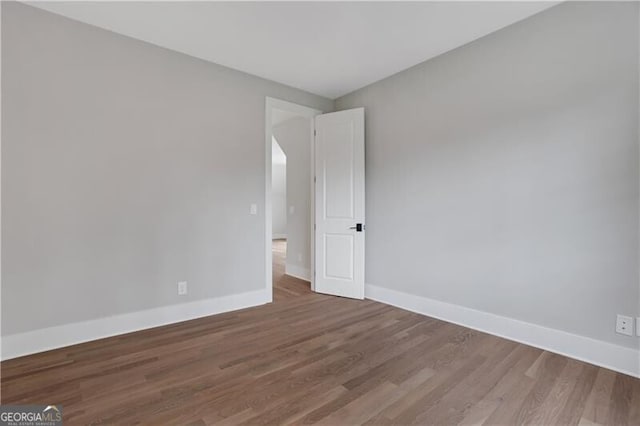 unfurnished room with hardwood / wood-style flooring