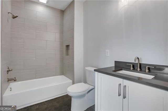 full bathroom with toilet, tile patterned flooring, tiled shower / bath combo, and vanity