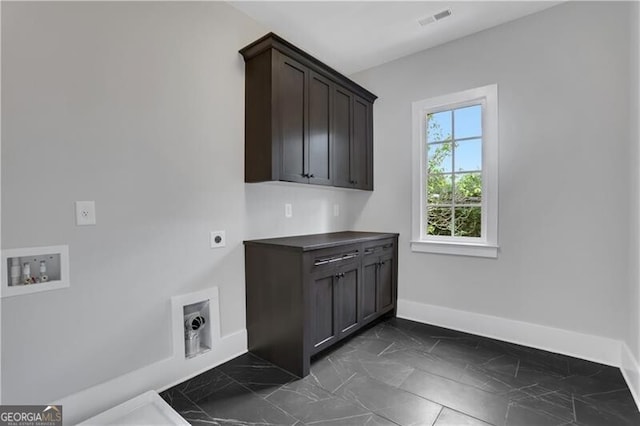 clothes washing area with washer hookup, cabinets, and hookup for an electric dryer