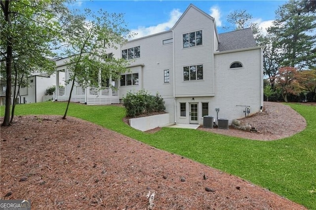 rear view of property with a lawn and central AC unit