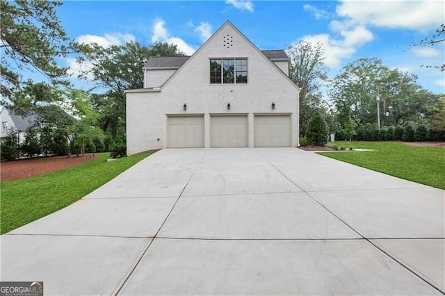 view of side of property featuring a garage and a yard