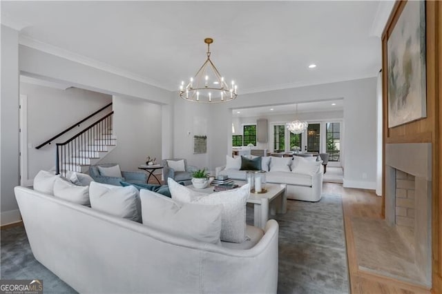 living room with dark wood-type flooring, a high end fireplace, ornamental molding, and a chandelier