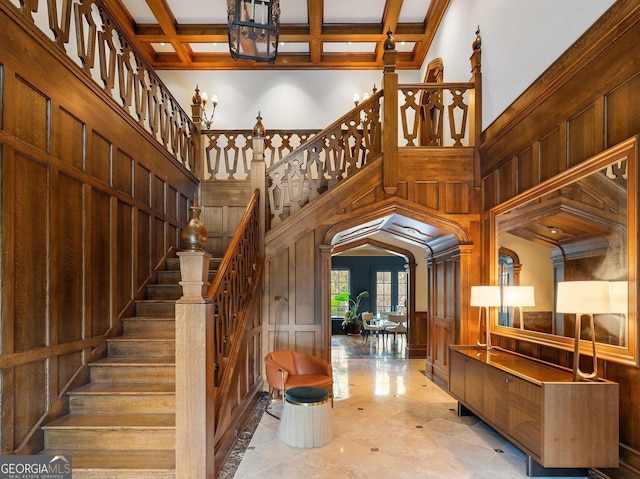 staircase with wooden walls, beam ceiling, and coffered ceiling