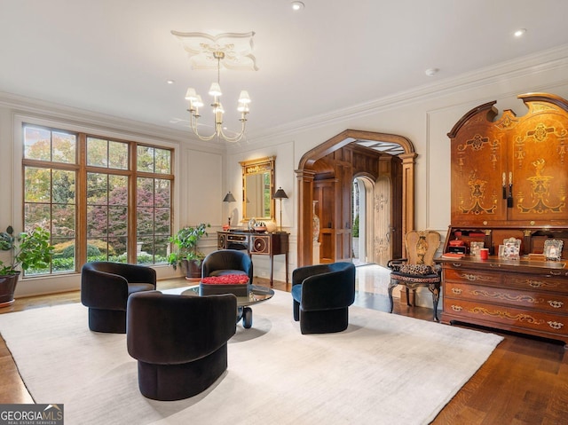 sitting room with an inviting chandelier, crown molding, and light hardwood / wood-style floors