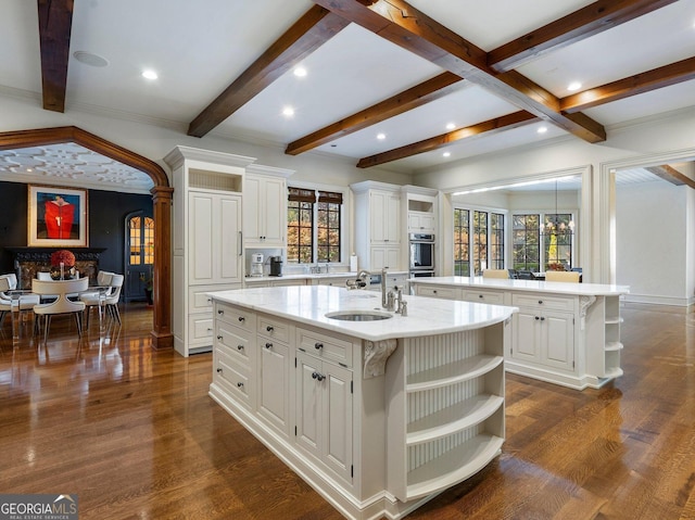 kitchen featuring white cabinets, a kitchen island with sink, and sink