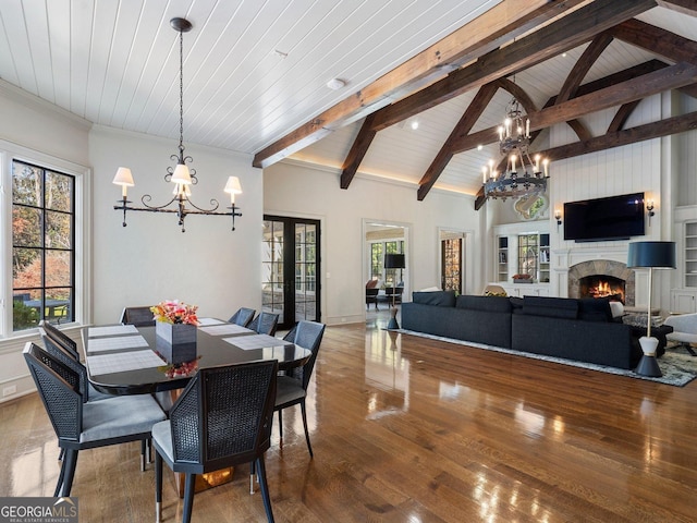 dining room with hardwood / wood-style floors, wood ceiling, french doors, an inviting chandelier, and beam ceiling