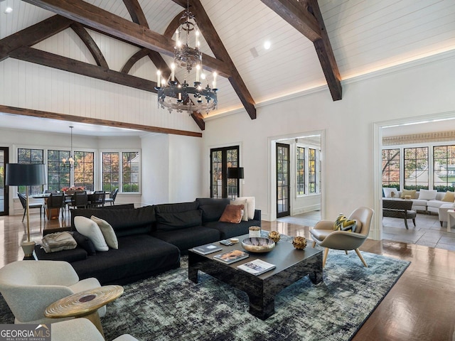 living room with light hardwood / wood-style floors, beamed ceiling, a healthy amount of sunlight, high vaulted ceiling, and a chandelier