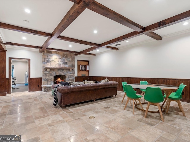 living room with a fireplace, beamed ceiling, wooden walls, and coffered ceiling